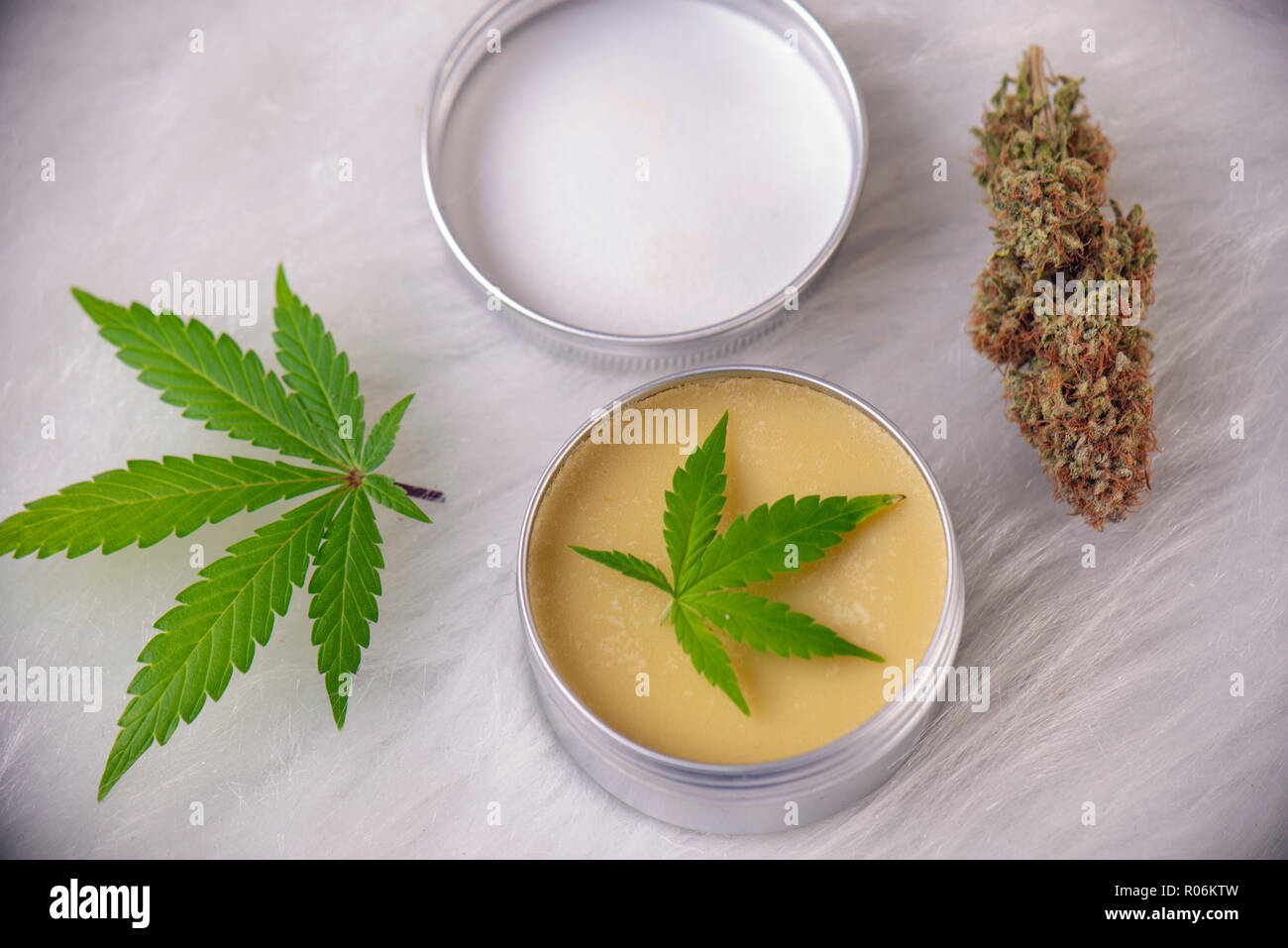 Cannabis hemp cream with marijuana leaves and nug over white background