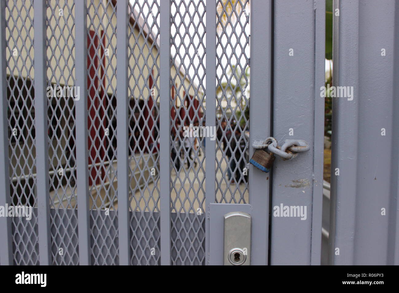 Closed high school campus - a lock on a heavy gate protects students from shootings and violence Stock Photo