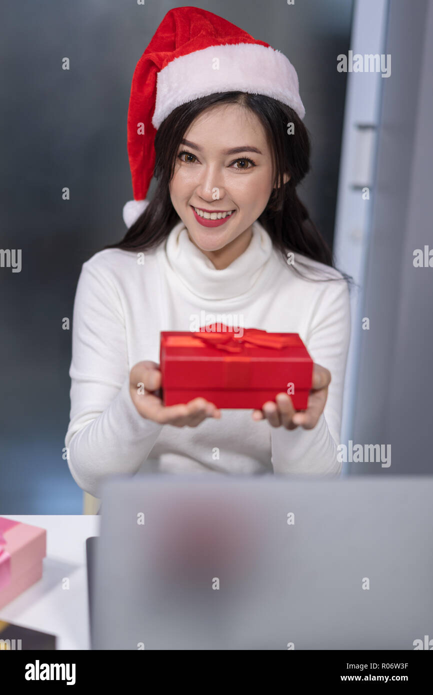 happy woman wear santa hat and christmas gift box with labtop computer ...