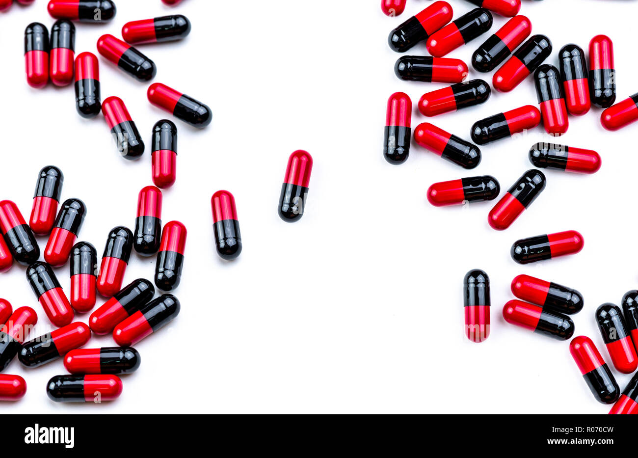 Red-black capsule pills spread on white background. Antibiotic drug use with reasonable. Pharmaceutical industry. Pharmacy background. Global healthca Stock Photo