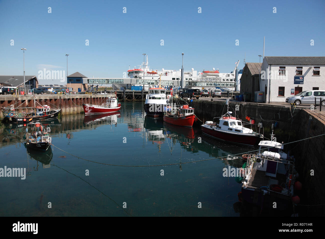 The harbour in Stromness, Orkney with fishing boats and the NorthLink ro-ro ferry Hamnavoe, operated by Serco Stock Photo