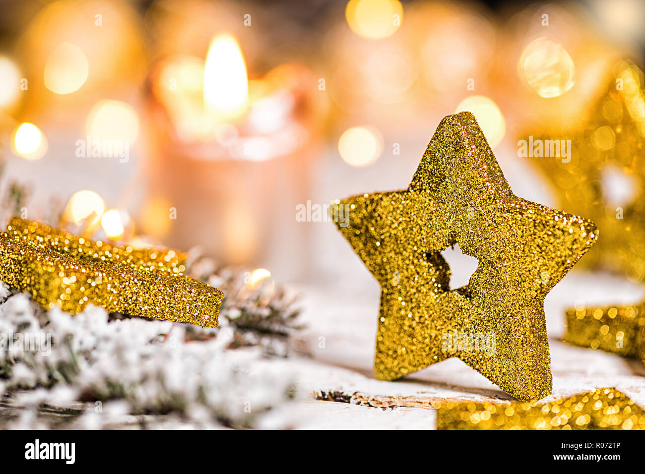 golden christmas star with candle, fir branch and lights on old wooden table Stock Photo