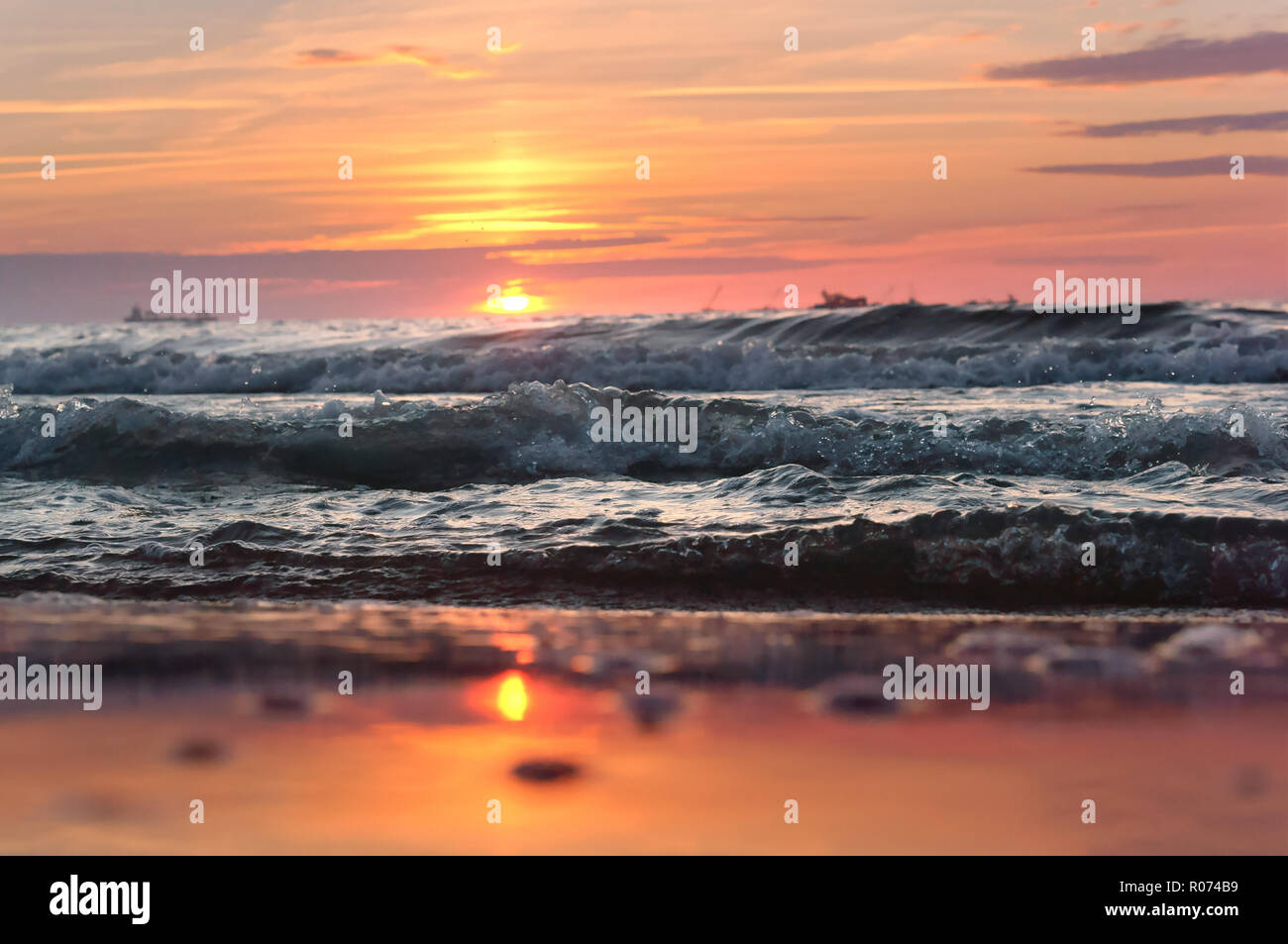 Sunset over the sea. Reflection of sunlight in the sea waves. Red sky in the rays of the sunset. Stock Photo