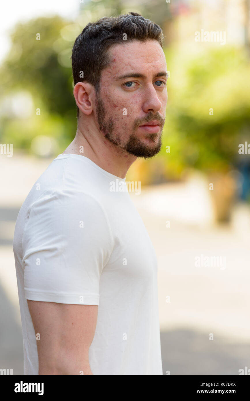 Young handsome Caucasian man standing at street outdoors Stock Photo