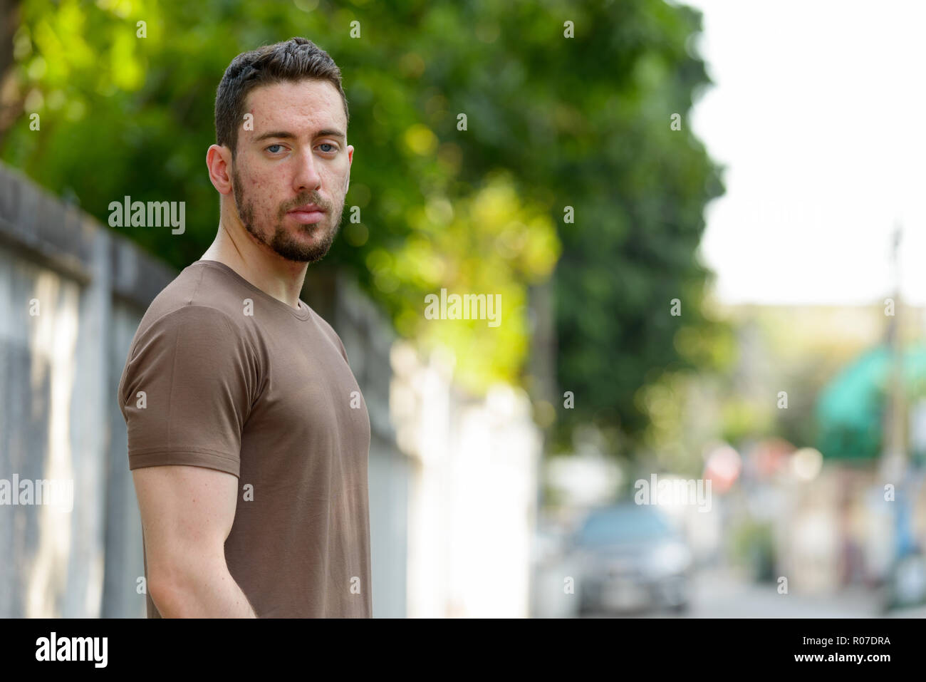 Young handsome Caucasian man looking at camera outdoors Stock Photo