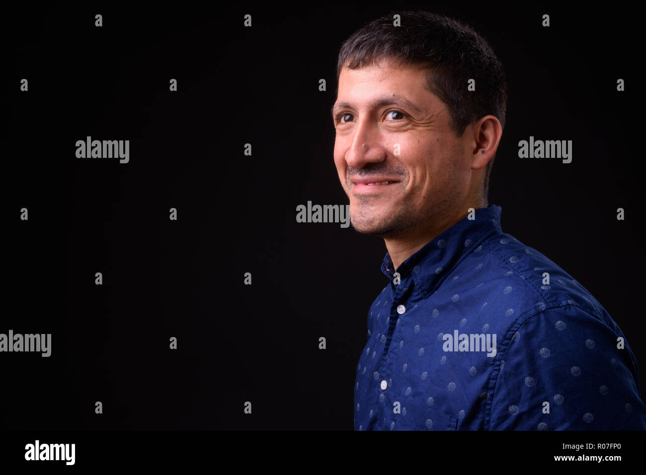 Portrait of Hispanic businessman against black background Stock Photo