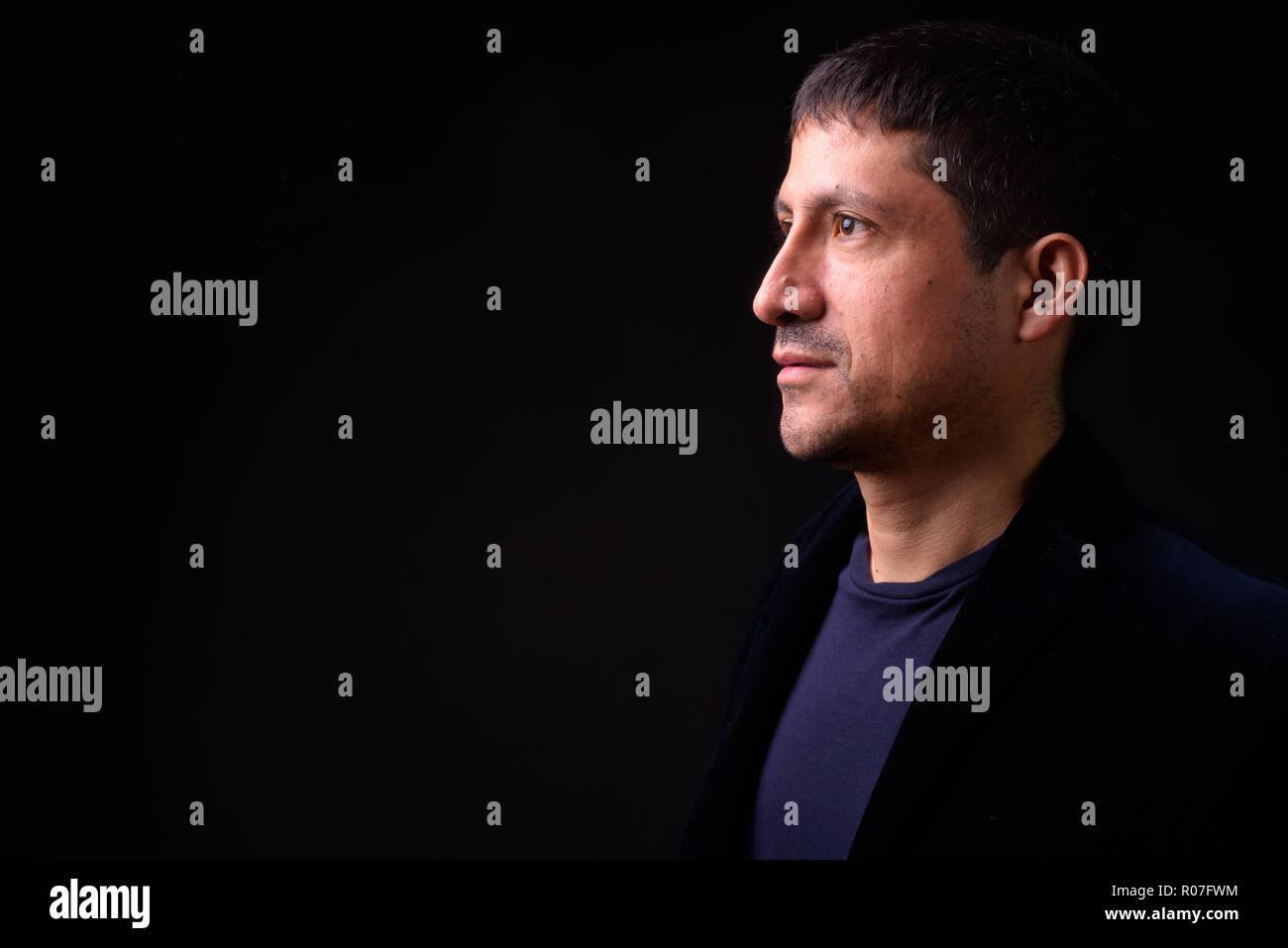 Portrait of Hispanic businessman against black background Stock Photo