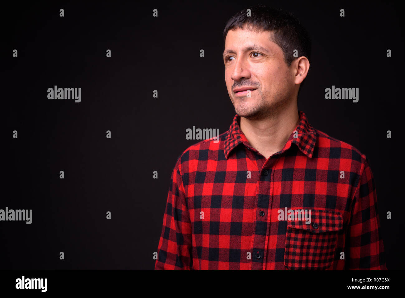 Portrait of Hispanic man against black background Stock Photo