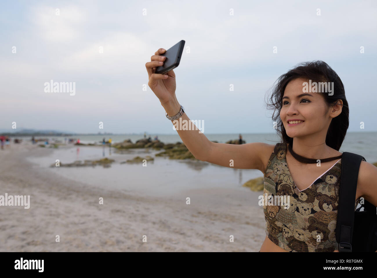 Young happy Asian woman smiling while taking selfie picture with Stock ...