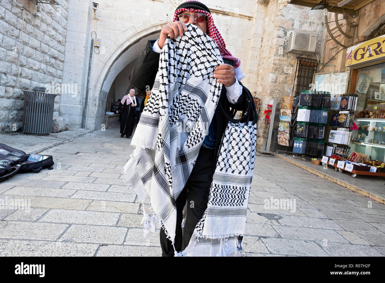 An older Arab man peddling arabic scarves to tourists in the Old City, Jerusalem, Israel. Stock Photo