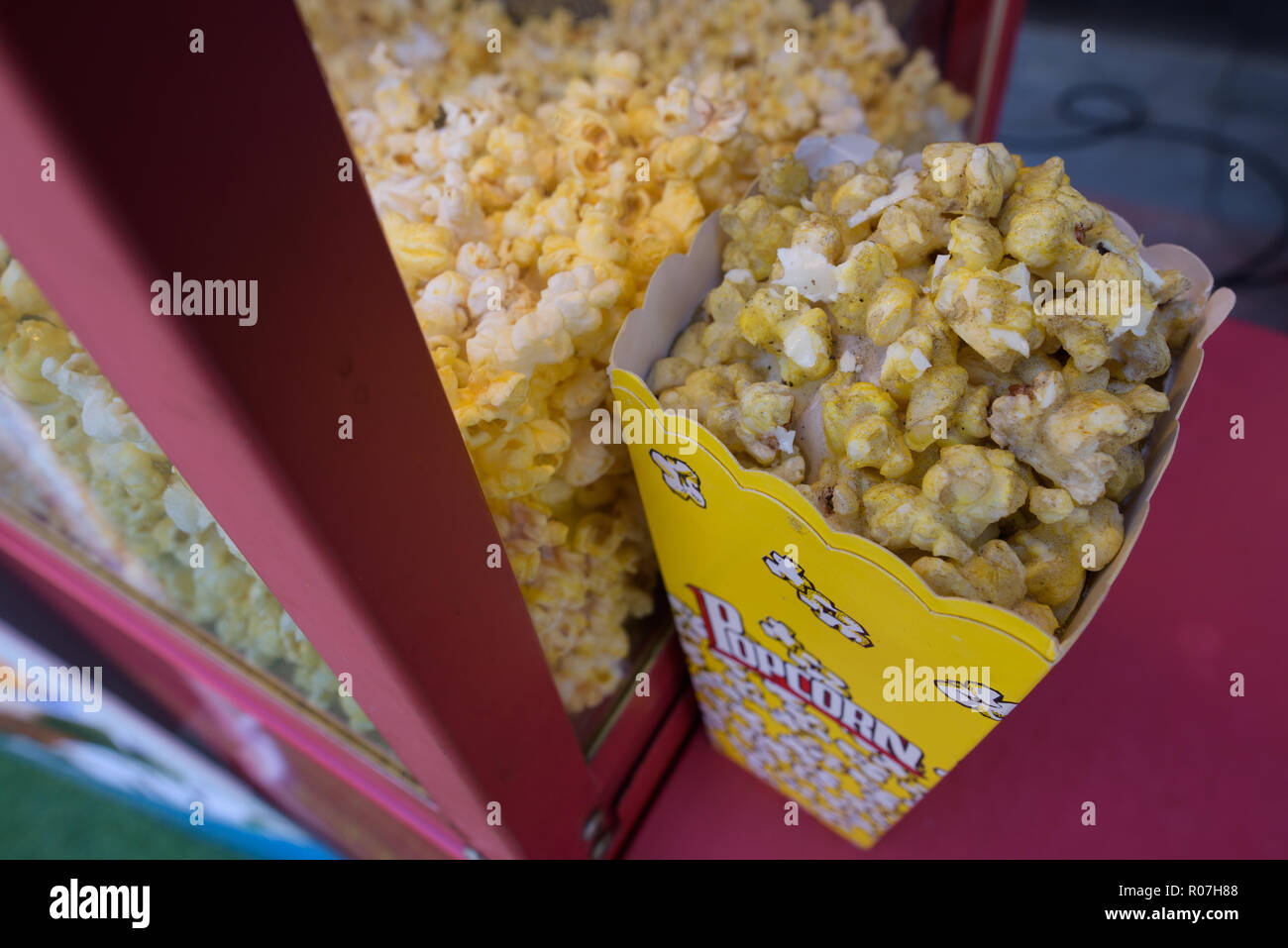 Delicious popcorns inside box with popcorn text Stock Photo