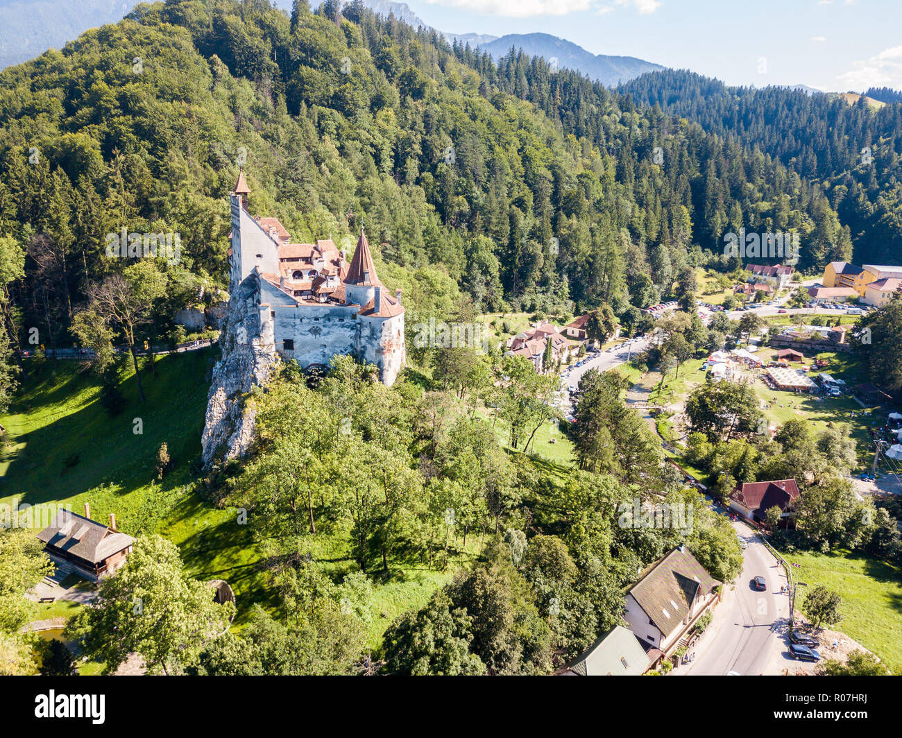 Bran castle on a hill with high spires, walls, red tiled roofs, surrounded by Bran town, Wallachia, Transylvania, Romania. Known as Dracula's Castle. Stock Photo