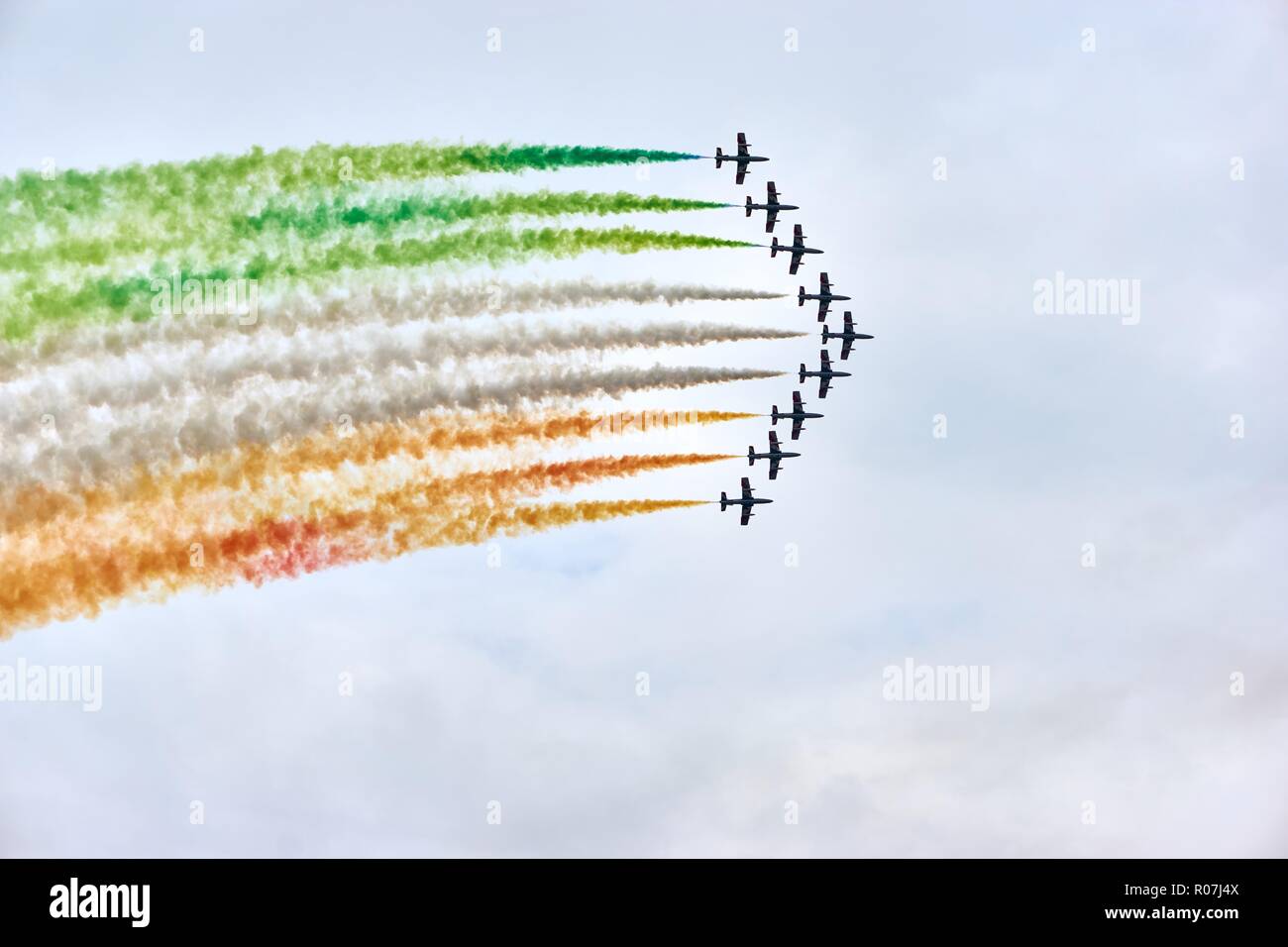 Airforce demonstration wit fighter jets or air planes in v formation with colors of the italian flag against a cloudy sky with copy space Stock Photo