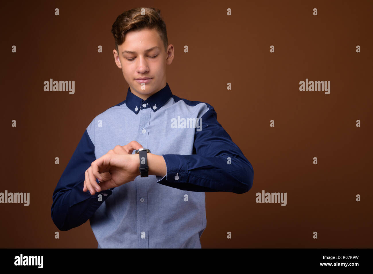 Young handsome teenage boy using smart watch Stock Photo
