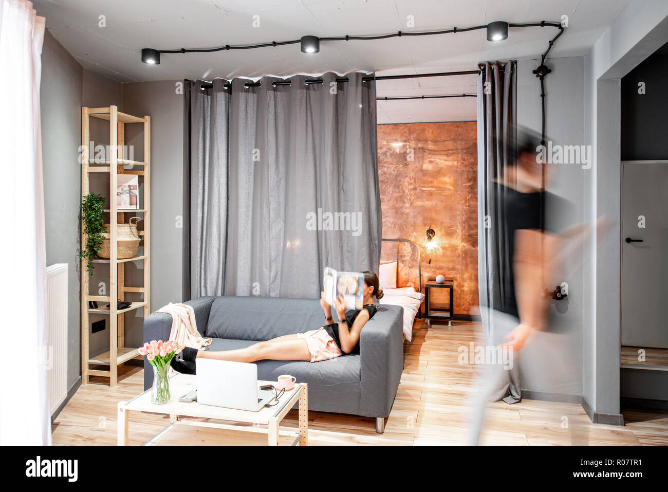 Modern living room interior with motion blurred couple doing their ...