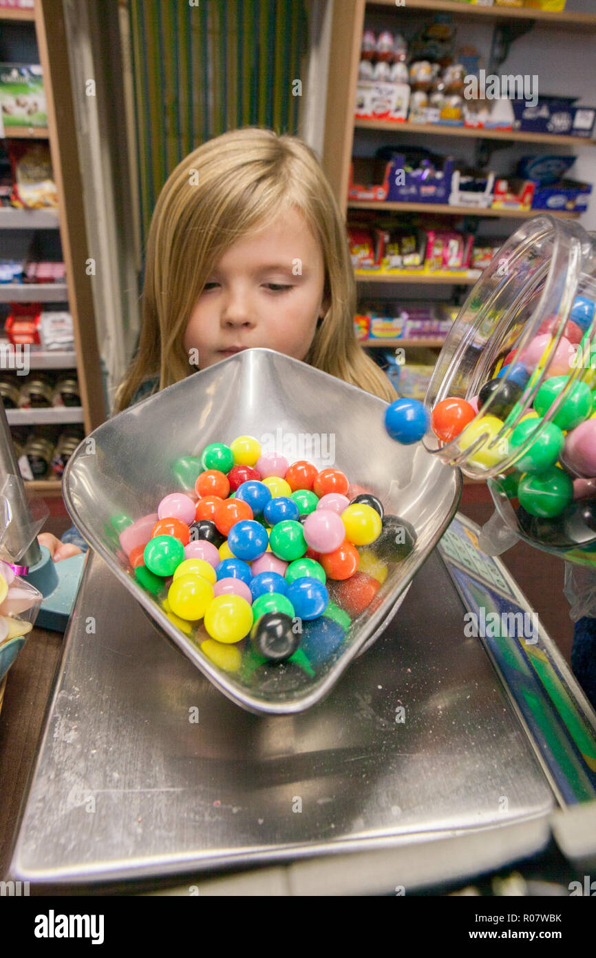 a young child in The Golden Butterfly sweet shop in Saffron Walden, Essex.  Owner, Michael Crisp Stock Photo