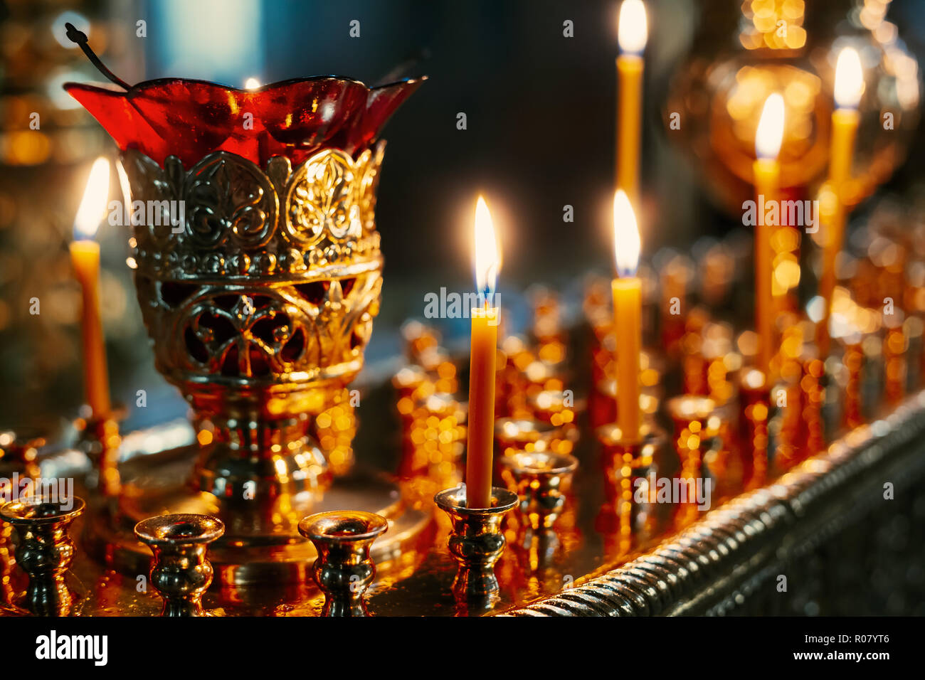 Row Candles In Church. Candle Light Flame In Worship. Stock Photo