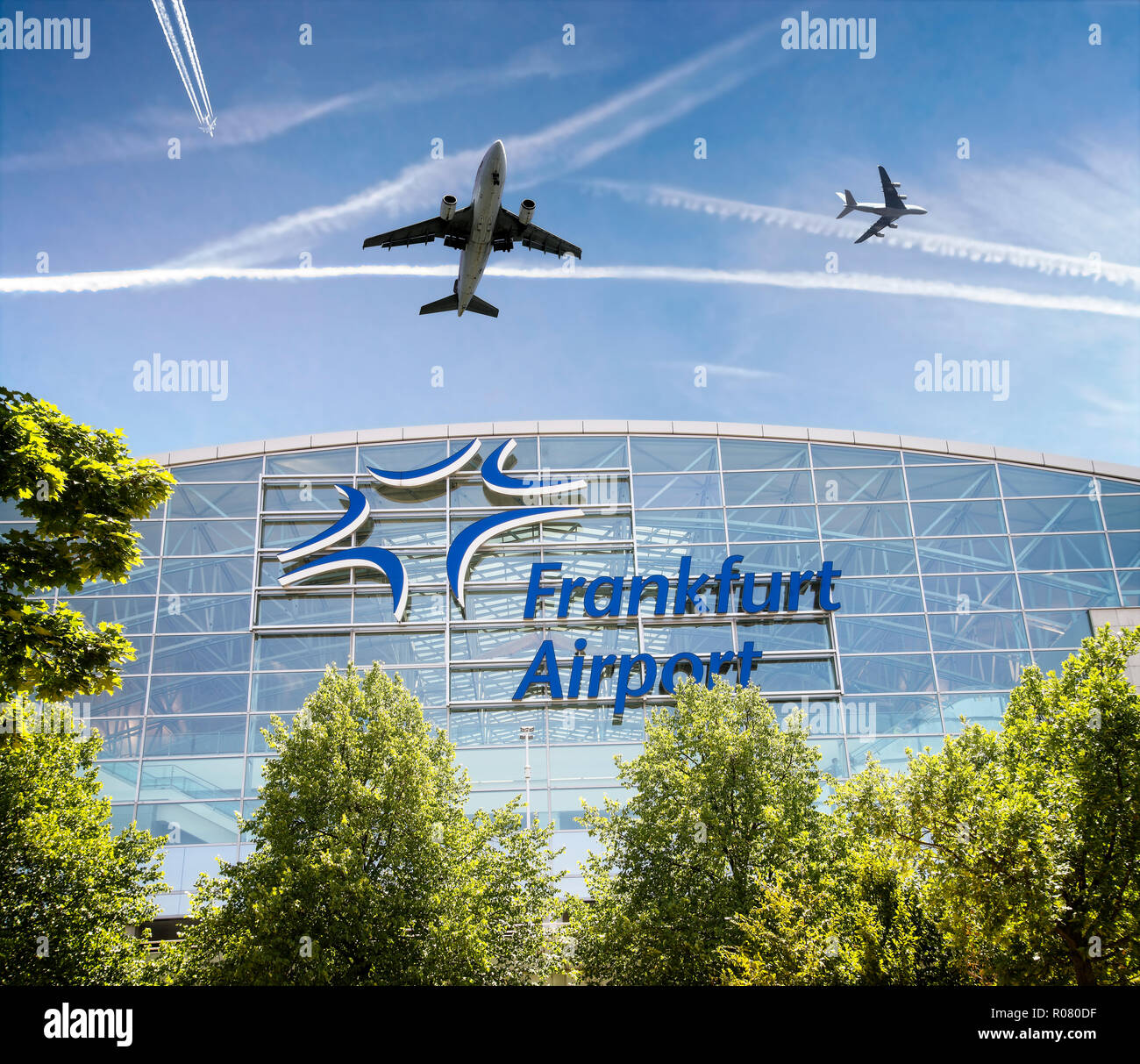 Terminal 2 at Frankfurt Airport with airplanes and contrails [M] Stock Photo