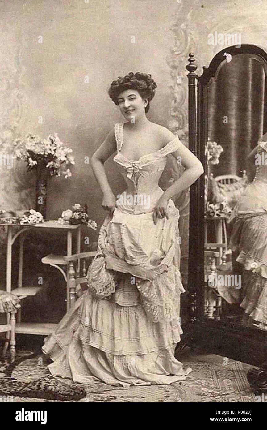 sexy young woman wearing corset dress posing in vintage studio