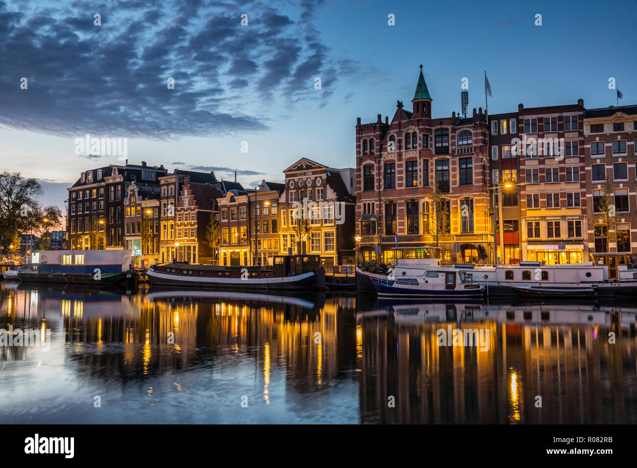 Amsterdan at night. Illuminated buildings and boats in water Stock Photo