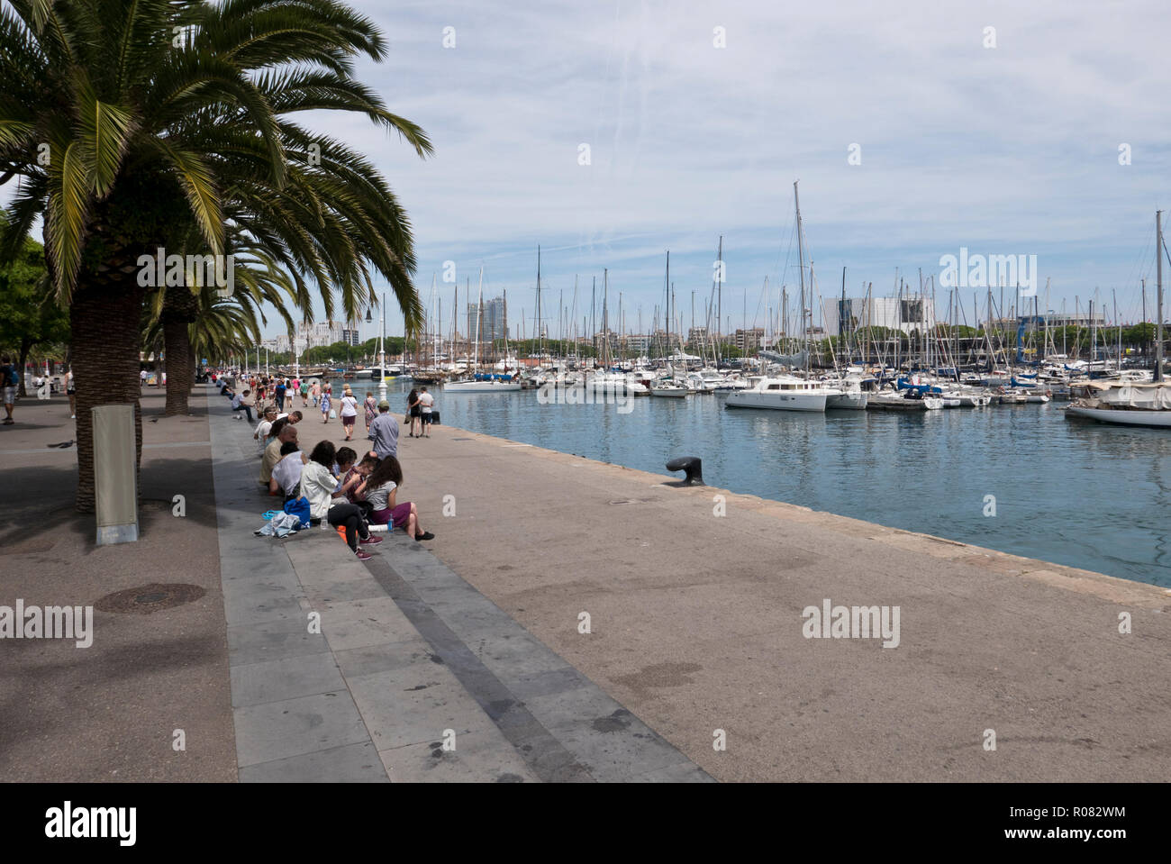 People walking along the promonade by the harbour in Barcelona, Spain Stock Photo