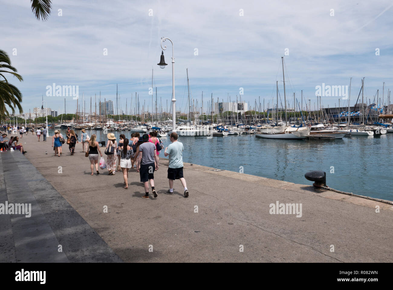 People walking along the promonade by the harbour in Barcelona, Spain Stock Photo