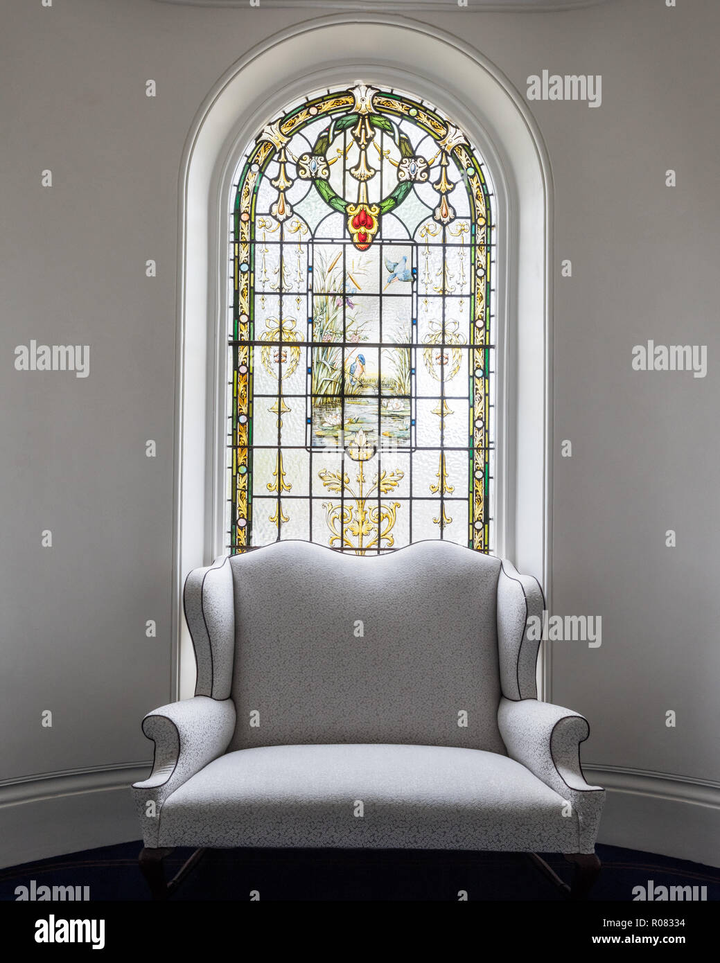 Armchair by stained glass window Stock Photo