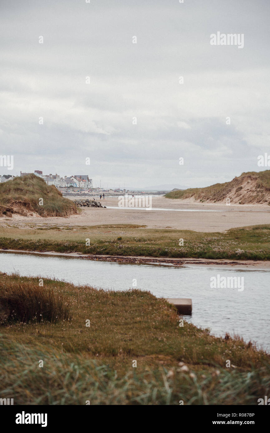 View of Rhosneigr from through the sand dunes on Cymyran beach, Anglesey, North Wales, UK Stock Photo