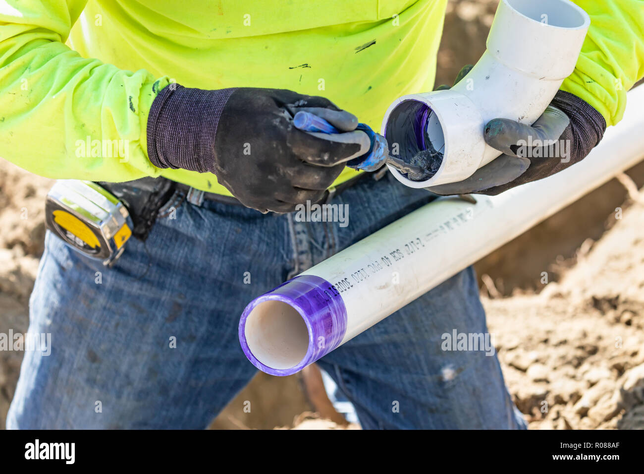 Plumber Applying Pipe Cleaner, Primer and Glue to PVC Pipe At Construction  Site Stock Photo - Alamy