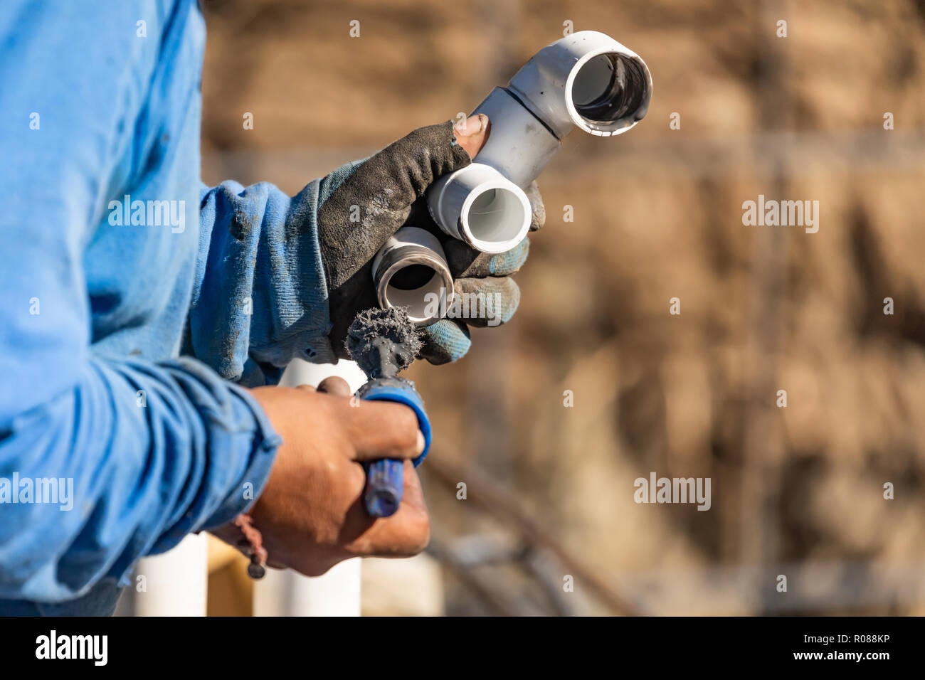 Plumber Applying Pipe Cleaner, Primer and Glue to PVC Pipe At