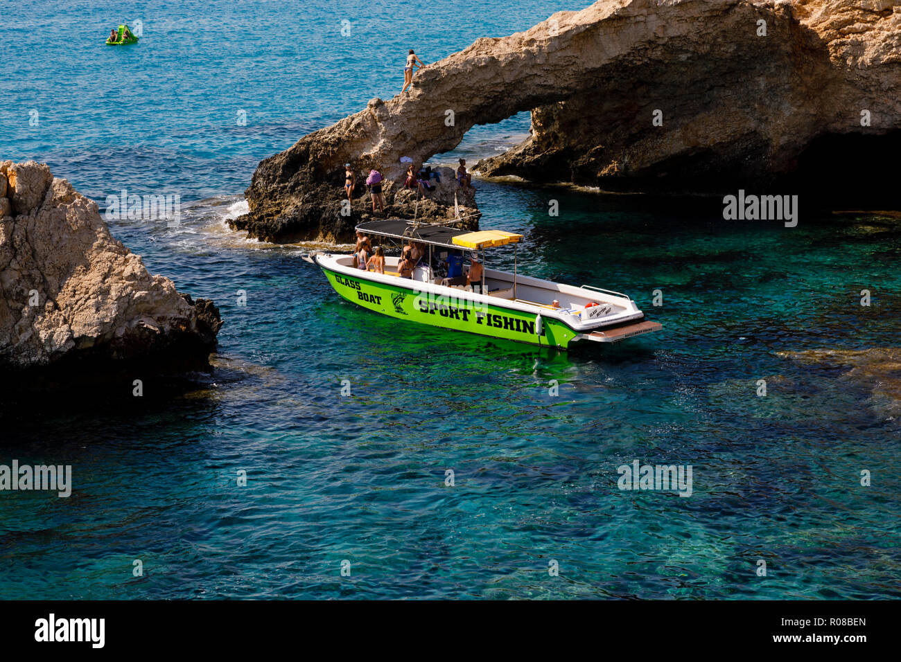 Glass bottom fishing boat at The Love Bridge arch, Ayia Napa, Cyprus October 2018 Stock Photo