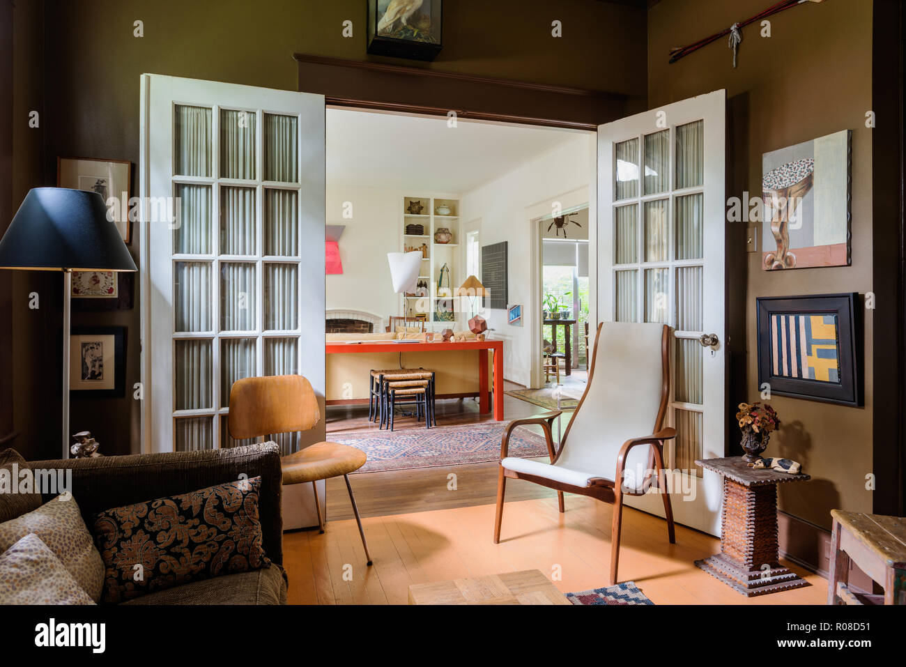 Chairs by open doors in retro living room Stock Photo - Alamy
