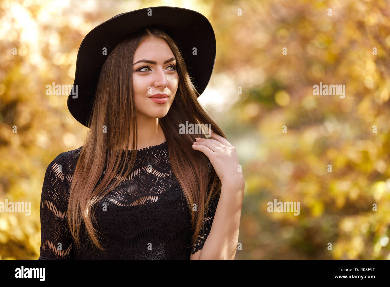 beautiful woman in black dress and hat in autumn Stock Photo - Alamy