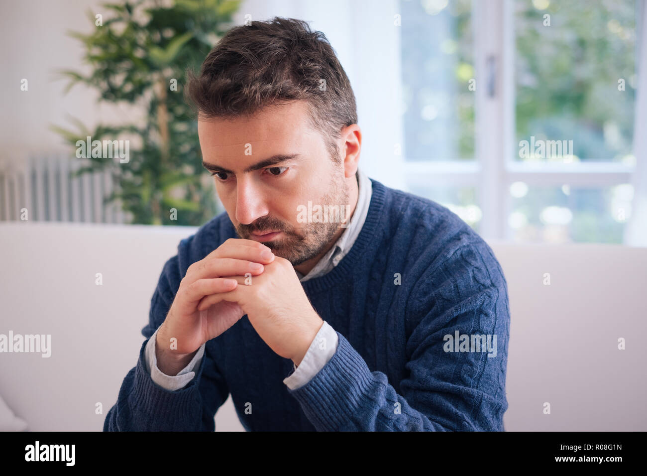 Sad and depressed portrait of man alone at home Stock Photo - Alamy