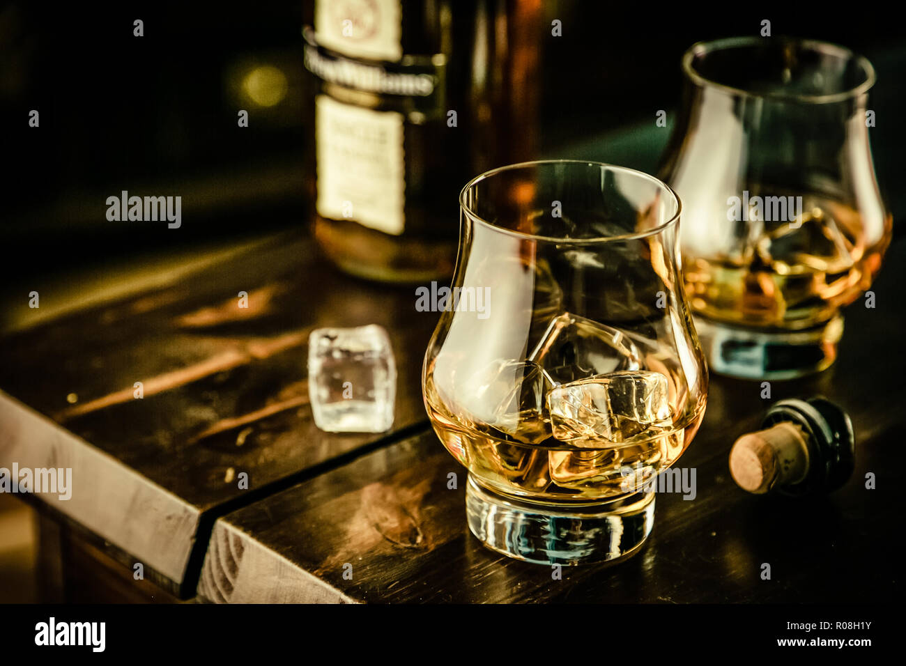 Whiskey in glasses with ice on rustic background, copy space Stock Photo