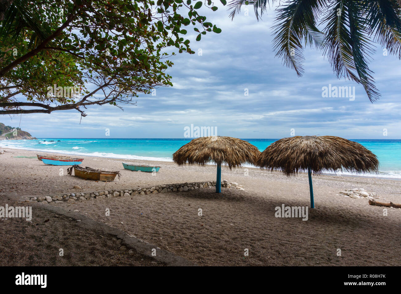 empty sandy beach with umbrellas and boats near the azure Caribbean sea. Dominican Republic Stock Photo
