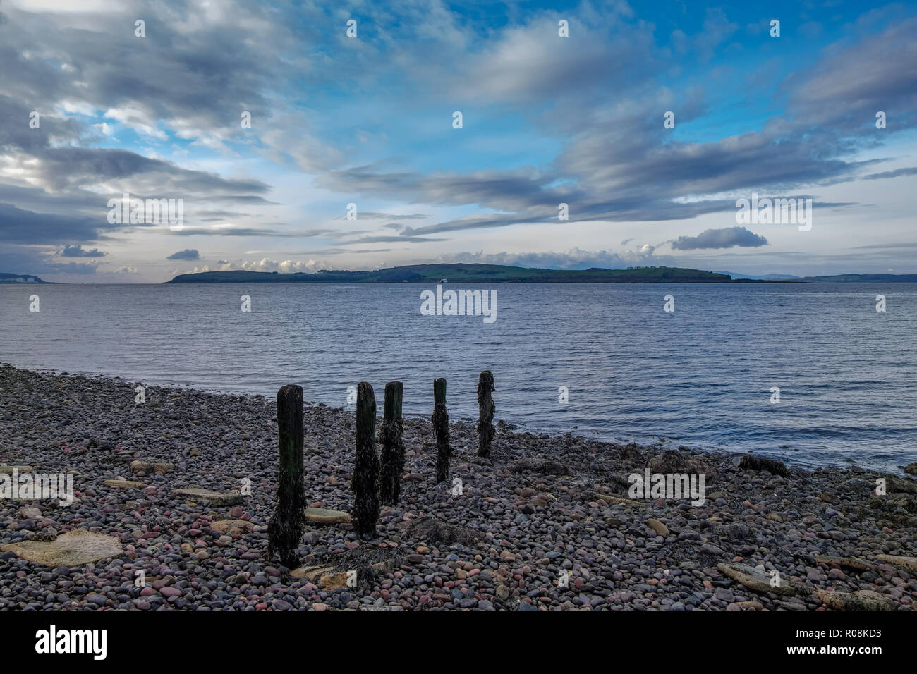 Looking over the old wooden pillars of  what was once the Hover craft jetty towards Millport on the Isle of Cumbrae Scotland. Stock Photo