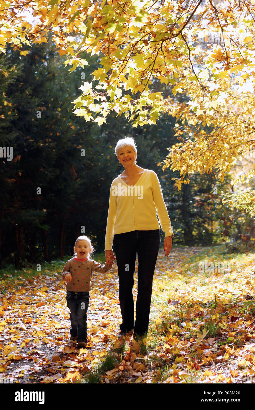 Grandmother with her granddaughter walking in autumnal forest, Czech Republic Stock Photo