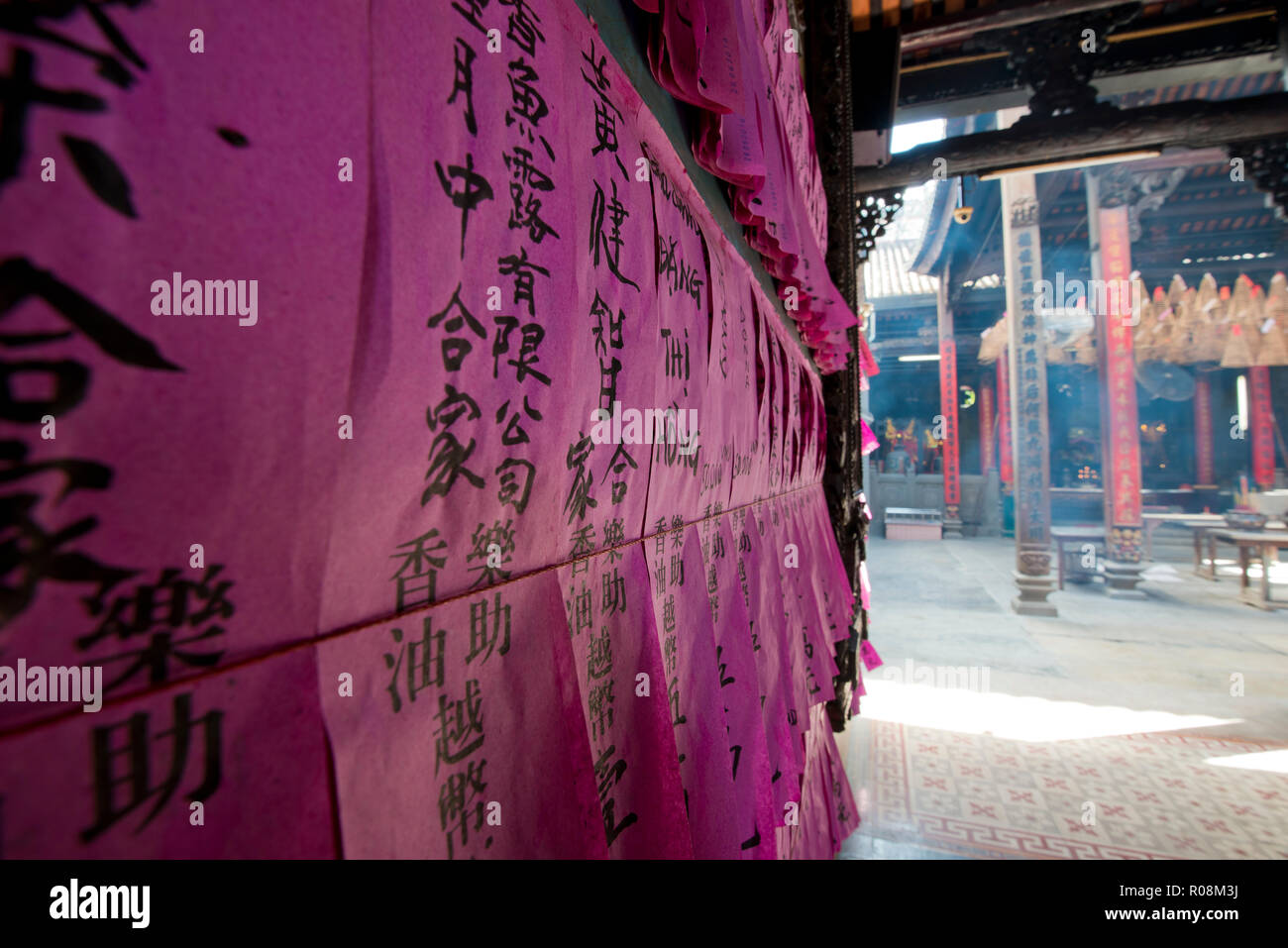 Prayer slip, black Chinese characters on pink tissue paper, in the temple Chua Thien Hau, Ho Chi Minh City, Saigon Stock Photo