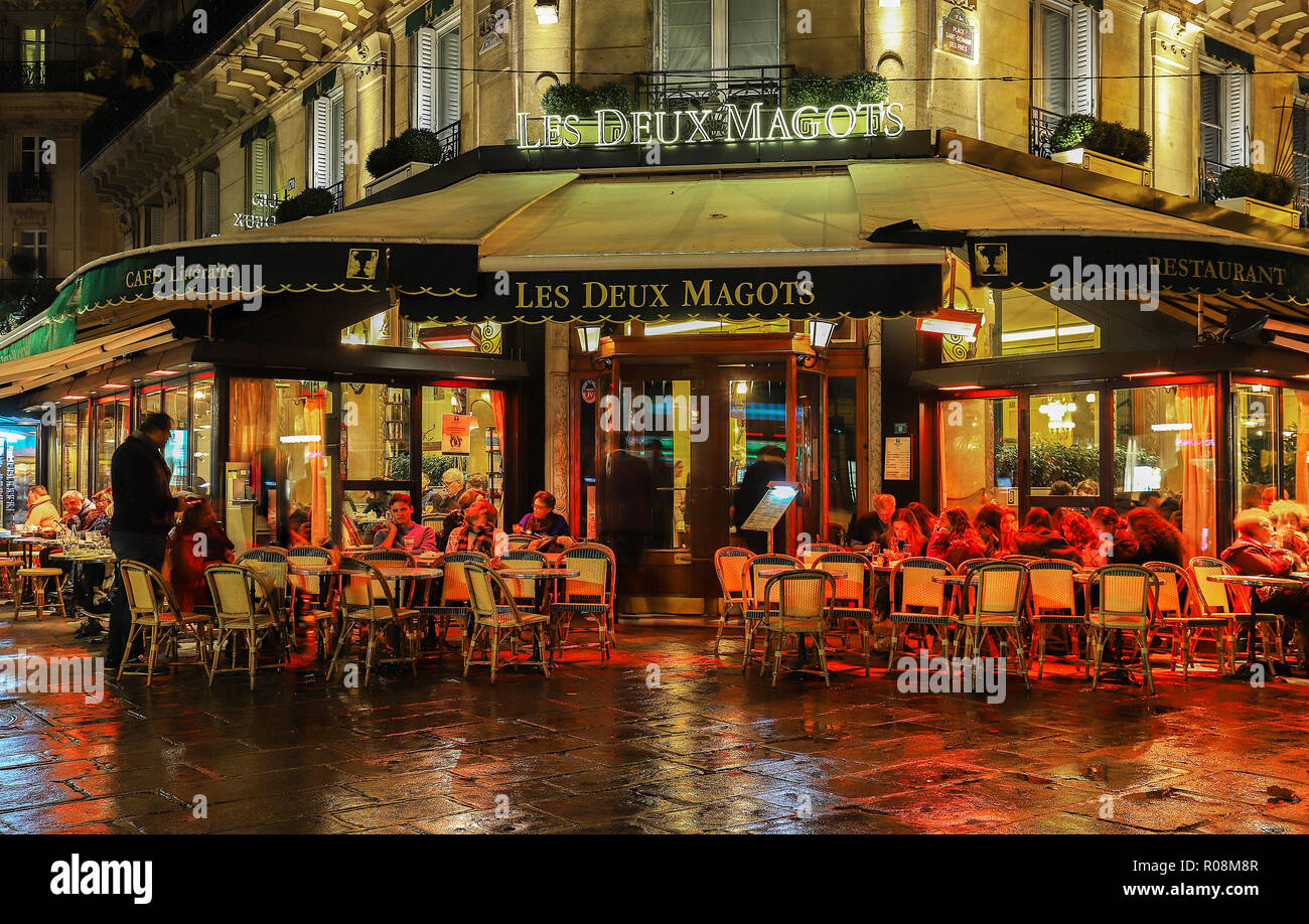 The famous parisian cafe Les Deux Magots at rainy night , Paris, France. Stock Photo
