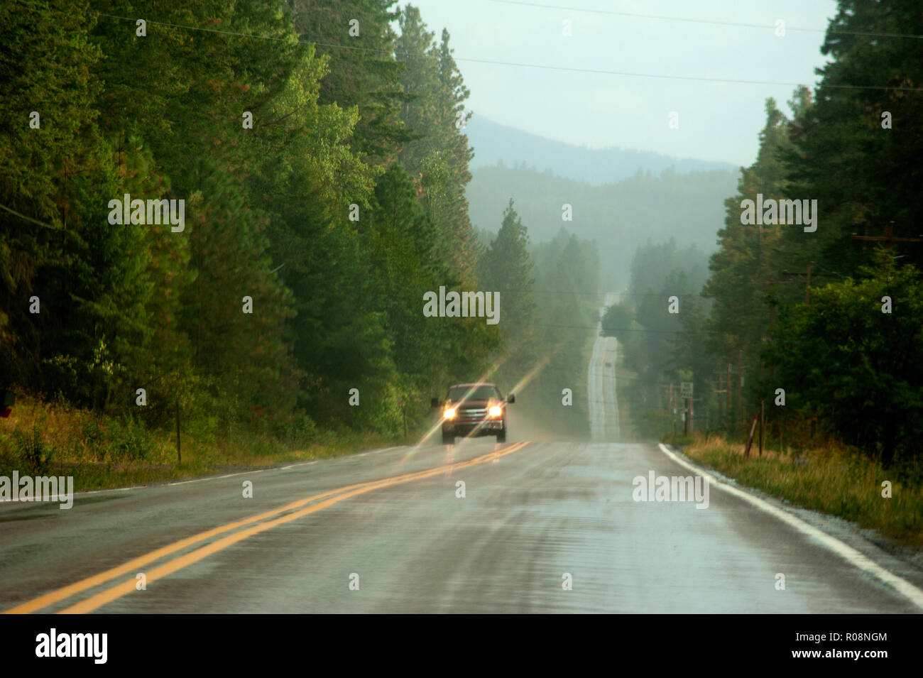 Truck driving on rain slicked road near Flathead Lake, Montana Stock Photo