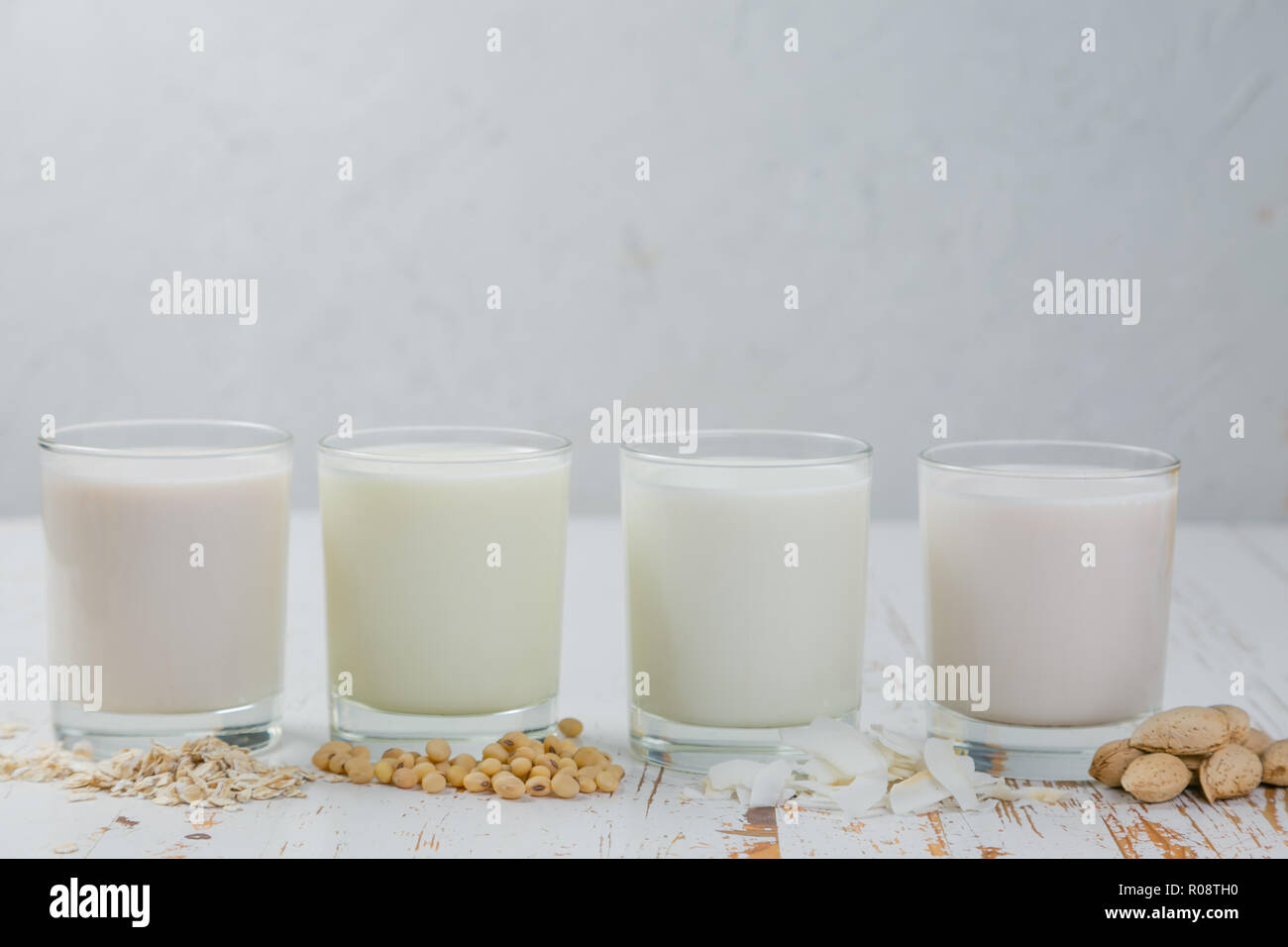 Non-dairy milk alternatives in glasses on white wood background Stock Photo