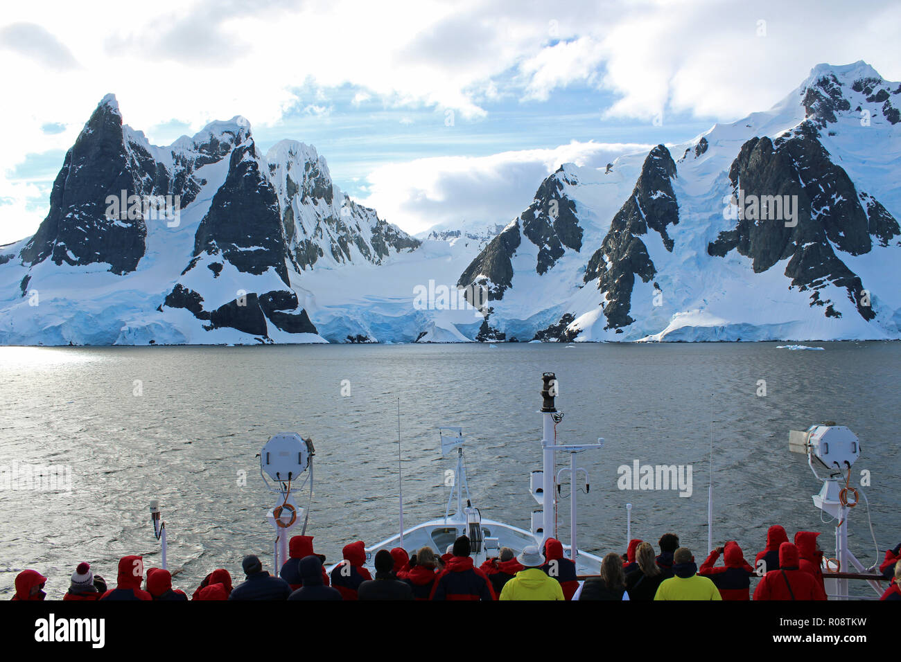 Expedition cruise passengers admiring the stunning views as their ships sails through the Lemaire Channel, Antarctica Peninsula Stock Photo