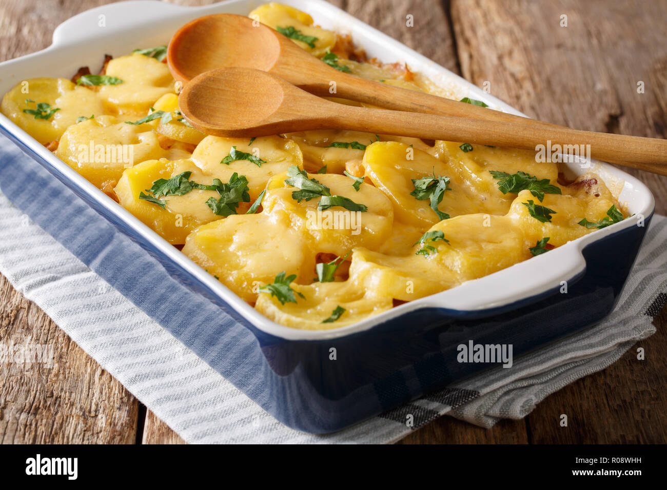 German sauerkraut casserole with potatoes, bacon and cheese closeup on