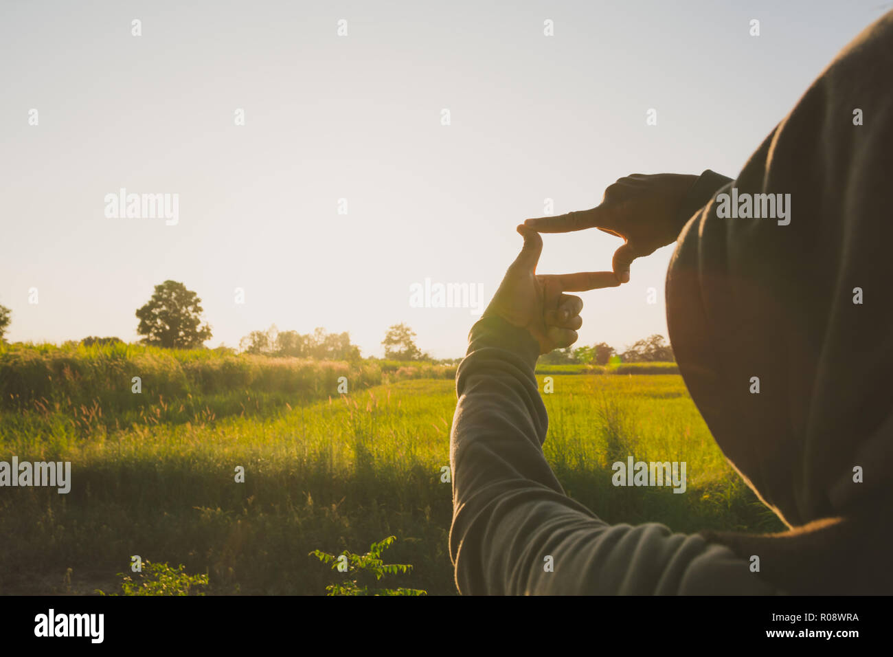 Hands making frame with sunset. Close up of woman hands making frame ...