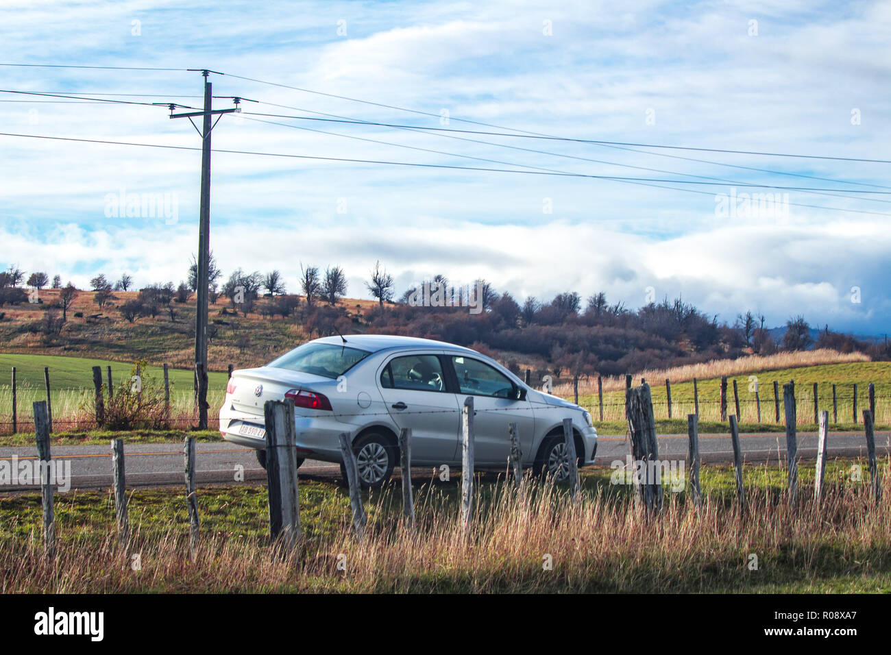 Car parked along the Austral Route at a rural area with wood fence and some grass Stock Photo