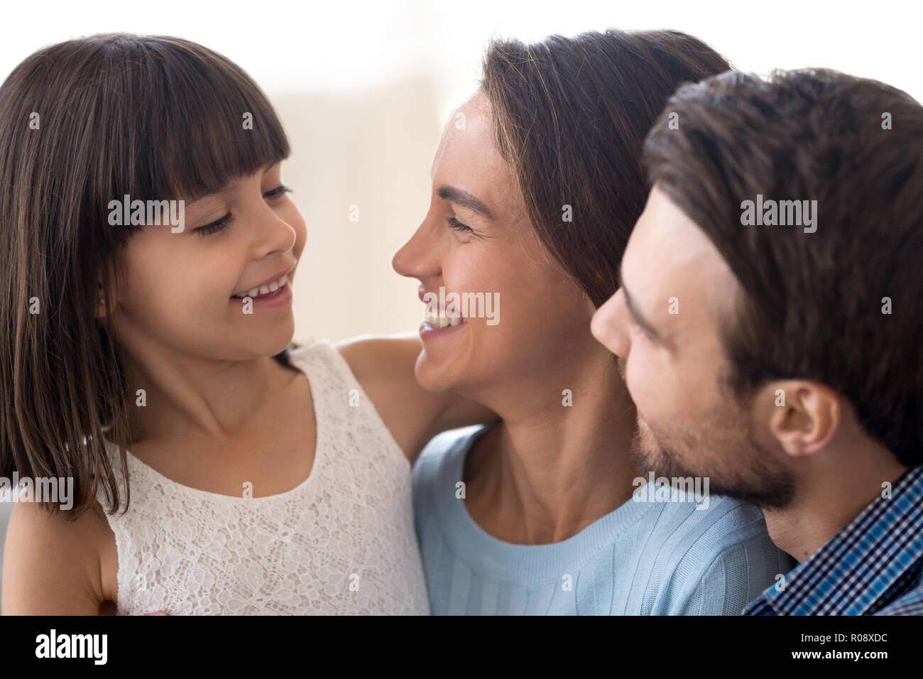 Close up smiling diverse family with small daughter Stock Photo
