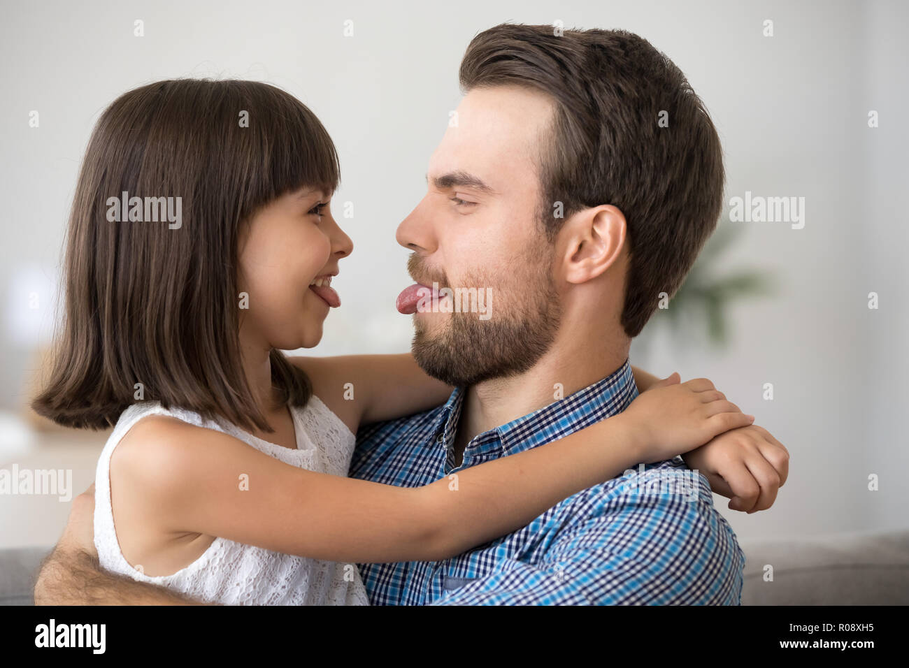 Father and daughter having fun showing each other tongues Stock Photo