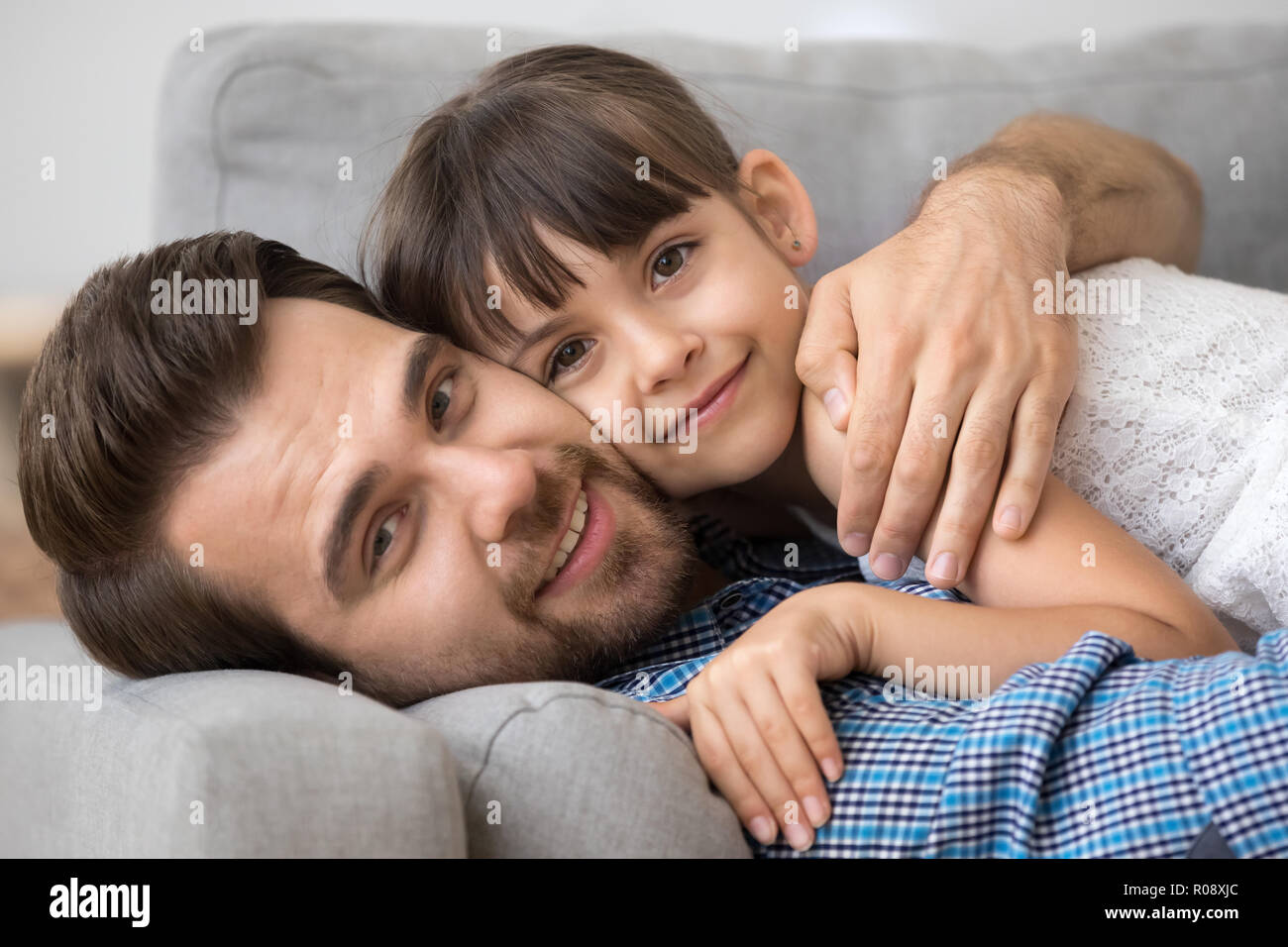 Father lying hugging with lovely daughter at home Stock Photo