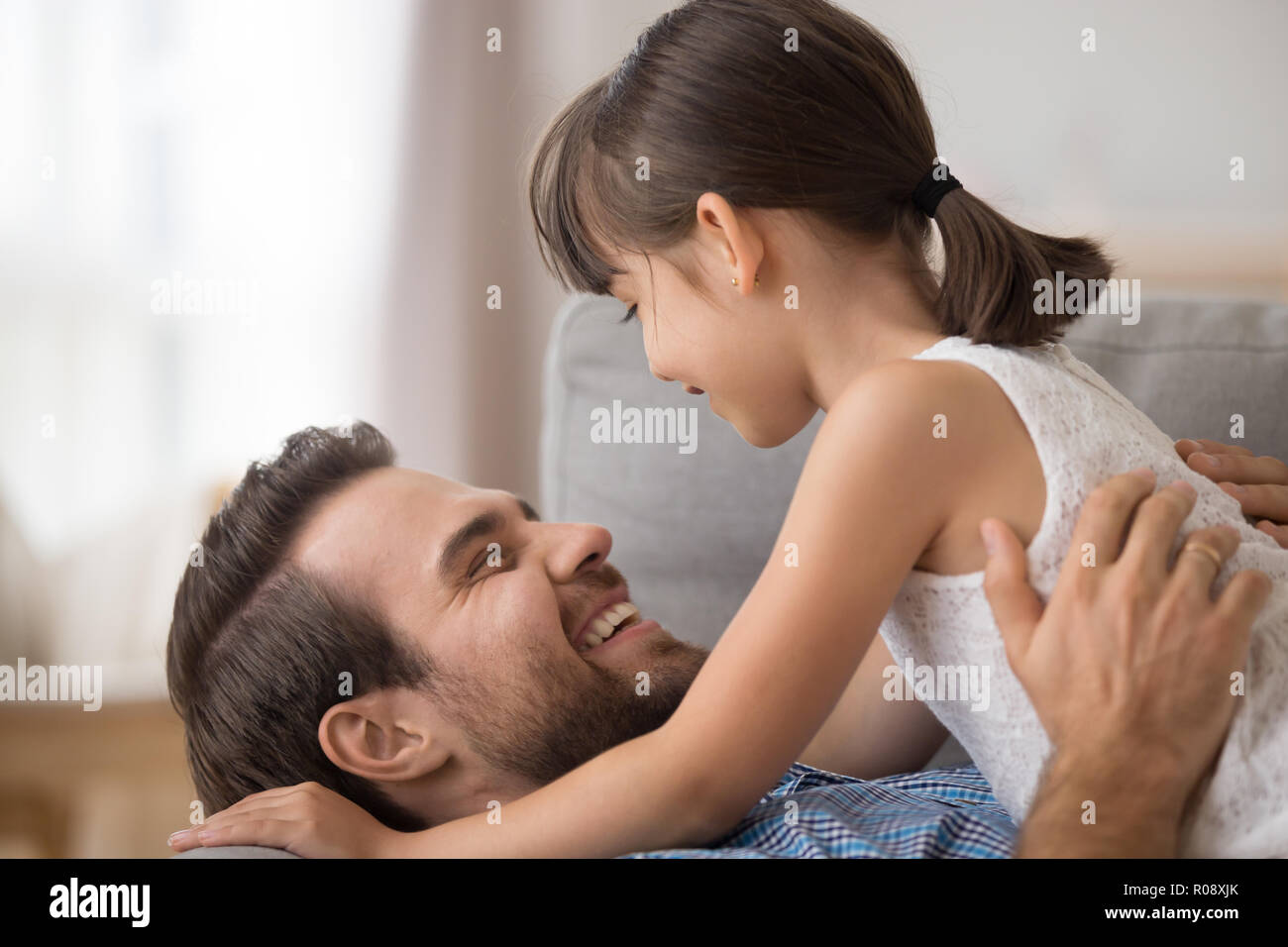 Close up father hugs daughter laughing together Stock Photo